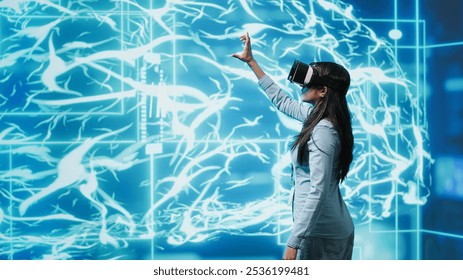 Developer wearing VR headset looking at hologram of artificial intelligence human brain simulation. Programmer interacting with AI visualization showing machine learning algorithms, camera A