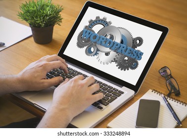 Developer or web designer at work. Close-up top view of man working on laptop with wordpress on screen. all screen graphics are made up.