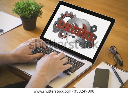 Developer or web designer at work. Close-up top view of man working on laptop with drupal on screen. all screen graphics are made up.