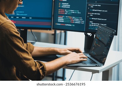 IT developer working online software development on pc monitors at modern home office on coding application screens, creating updated latest program firmware information version concept. Gusher.