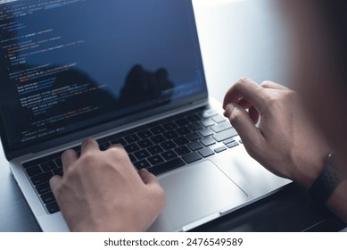 Developing programmer, software developer coding computer code on laptop computer. Digital software development. Website and mobile app design and coding technologies.