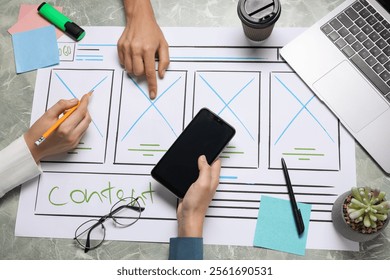Developing UI design. Designers creating website wireframe on paper at grey marble table, top view