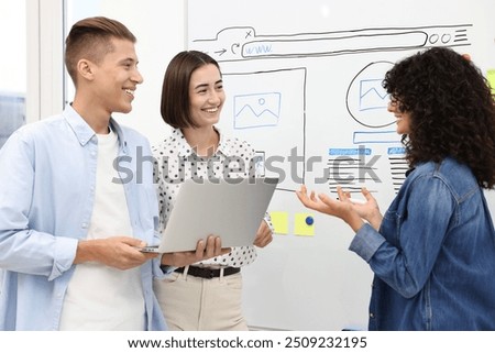 Developing UI design. People drawing website wireframe on whiteboard indoors