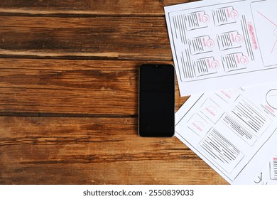 Developing UI design. Sketches of website wireframes and smartphone on wooden table, top view. Space for text