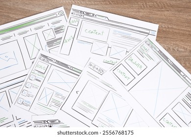 Developing UI design. Sketches of website wireframes on wooden table, top view