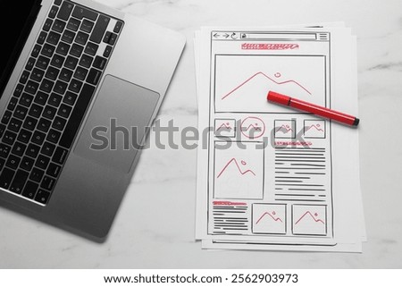 Developing UI design. Sketches of website wireframes, laptop and felt pen on white marble table, top view