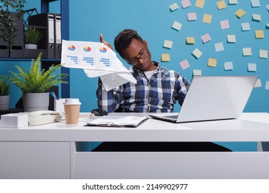 Development Agency Employee In Office, Reviewing Marketing Campaign Plan Statistics. Young Adult Entrepreneur Analyzing Financial Documentation And Project Management Charts While In Workspace.