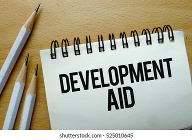 Development Aid Text Written On A Notebook With Pencils