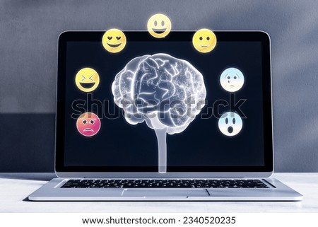 Development of emotional intelligence concept. Polygonal human brain and various human emotions: fear, surprise, joy, sadness, anger. Close up of laptop with hologram on blurry background