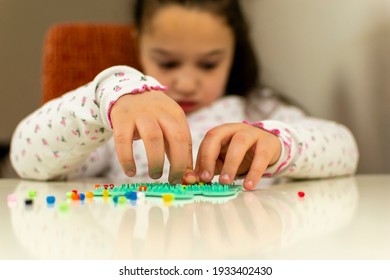 Development Of Fine Motor Skills In Children. The Blind Child Puts Together A Plastic Mosaic. The Hands Are On The Mosaic. Learning Through Play