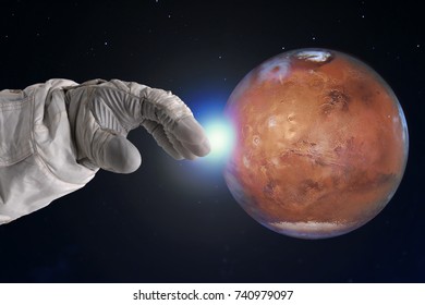 The development of Mars, concept. Hand of astronaut reaches out to Mars. Elements of this image furnished by NASA.