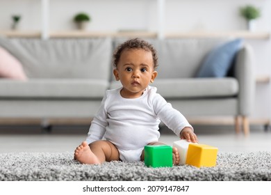 Developmental Toys Concept. Cute Little Black Infant Boy Playing With Colorful Building Blocks At Home, Adorable African American Baby Wearing Bodysuit Sitting On Carpet In Living Room, Copy Space