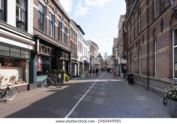 DEVENTER, NETHERLANDS - APRIL 17 2021: Shopping\
street Nieuwstraat in Deventer. There is a white line on the pavers\
to indicate walking direction in connection with the corona\
covid-19 lockdown