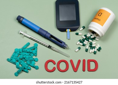 Device To Measure Blood Glucose, Vitamin D Box And The Word Covid Written In Green Background, Top View