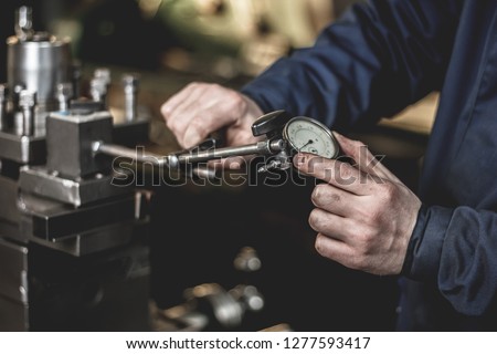 the device for measuring the end runout. Concept micrometer with measuring scale and indicator, lathe, profession Turner, equipment, beat check.