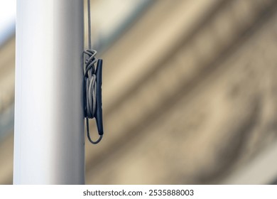 device mounted on a flagpole designed for efficiently coiling rope, illustrating practicality and functionality in design - Powered by Shutterstock