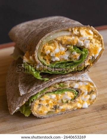 Devil egg wraps healthy breakfast on wooden cutting board. Close-up photo of a fresh, light meal with creamy devil eggs wrapped neatly. Ideal for a healthy start to the day