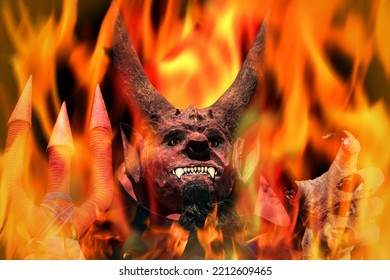 Devil On Fire On A Dark Background. Man In Scary Devil Mask, Halloween. Holding Out His Hand. Hell Concept.