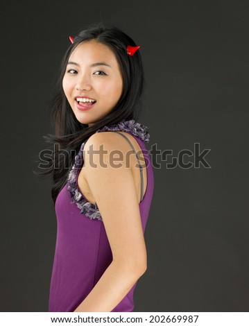 Devil side of a young Asian woman smiling