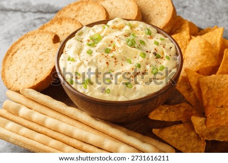Deviled Egg Dip festive buffet appetizer with chips, breadsticks and biscuit close-up in a plate on the table. Horizontal