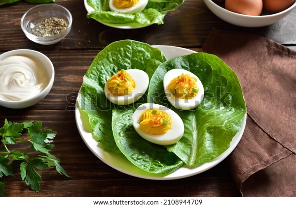 Deviled eggs with paprika,
mustard and mayonnaise on plate over wooden background. Close up
view