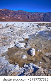 Devil's Golf Course Salt Formations and Rugged Mountains Under Clear Blue Sky