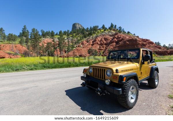 DEVILS TOWER NATIONAL\
MONUMENT, WYOMING - July 4, 2014: An Inca Gold Jeep Rubicon parked\
with the top down in the sunshine at Devils Tower NM, Wyoming on\
July 4, 2014.