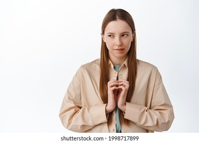 Devious young woman scheming, looking aside at logo with pensive cunning face, steeple fingers, have evil genius plan, thinking, standing over white background