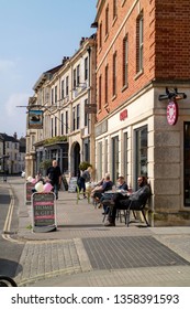 Devizes, Wiltshire, England, UK. March 2019.  Customers Seated Outside A Pub And Coffee Shop On The Main Street.