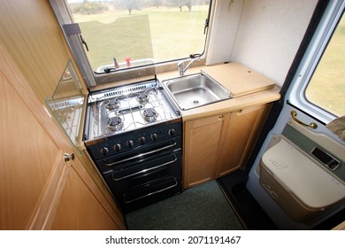 Devon England. Interior of a coach built motor caravan showing end kitchen with full sized cooker and sink with cupboards underneath.