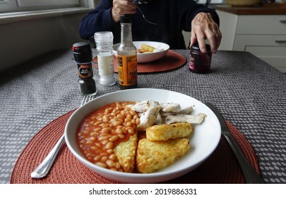 Devon England. White China Bowl Containing Hash Browns, Baked Beans And Turkey Pieces Being Served On A Tablecloth. Condiments On The Table. Person In Rear Eating Lunch.  