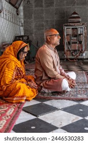 devotee couple praying for holy god at temple at morning from flat angle