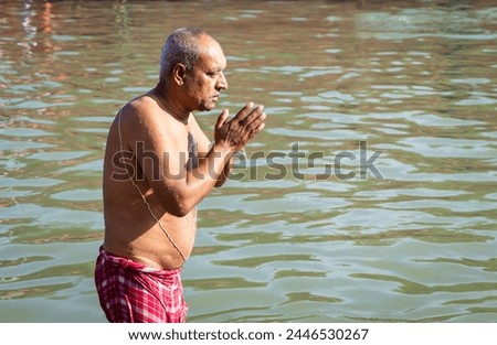 devotee praying after bathing in holy river water at morning from flat angle