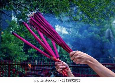 Devotees hold burning incense during a Chinese New Year prayer ceremony at Vihara Dharma Bhakti, a historic Chinese temple in Jakarta's Chinatown, Indonesia.