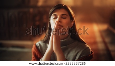 Devout Praying Christian Woman, Bowing In Humble Reverence To God. With Hands Folded She Looks Upwards Before Closing Eyes. Seeking Guidance and Strength to Live a Life in Accordance with The Bible