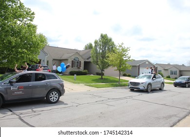 Dexter, Michigan / United States - May 23 2020: Drive-by Celebration Local Dexter Michigan Soccer Coach Retirement Coronavirus Drive-by People Wearing Masks Waving Social Distancing Parade COVID19