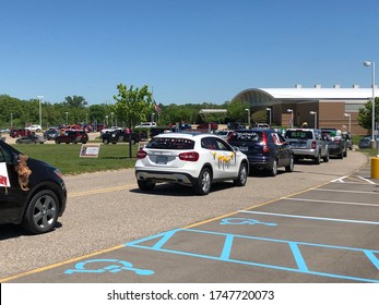 Dexter, Michigan / United States - May 31 2020: High School Seniors Parade During Coronavirus Pandemic Coronavirus Drive By Parade Celebration For High School Seniors Line Of Cars Balloons And Posters