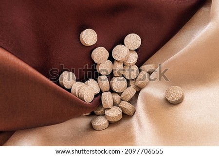 DGL (licorice root extract) chewable tablets on silk background. immune prevention care concept