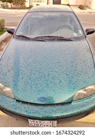 Dhahran, Saudi Arabia - March 13 2014:  Green Chevy Cavalier Car, Completely  Filthy After A Sandstorm In Saudi Arabia.