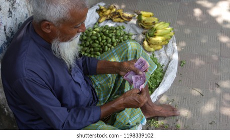 Dhaka, Bangladesh - 09 18 2018: Asian Old Man With White Beard Sale Fruit In Street. Middle Aged Poor Man Working In Local Market To Earn Money. Government, NGO Help Needed Common People World. CSR