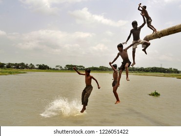 Dhaka, Bangladesh - April 23, 2010: Children jumping and playing at the bank of the Turag River in Dhaka, Bangladesh on  April 23, 2010.