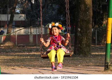 Dhaka , Bangladesh: February 13, 2021: Adorable Little Girl Swinging In A Park Celebrating First Day Of Spring , Selective Focus