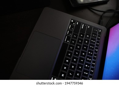 Dhaka, Bangladesh - February 28 2019: A Space Grey MacBook Laptop On Top Of A Desk In A Studio With Backlit Keyboard  