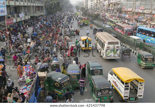Dhaka, Bangladesh - February\
3, 2017: Busy traffic filling a street in central Dhaka. Cycle\
rickshaws, buses, people and cars compete for space on the crowded\
street.