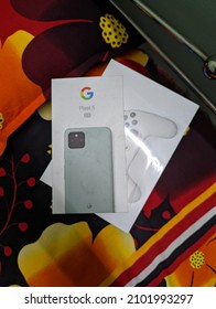 Dhaka, Bangladesh - January 04 2022: A Game Controller And A Smartphone On Their Box On Top Of The Colorful Bedsheet  