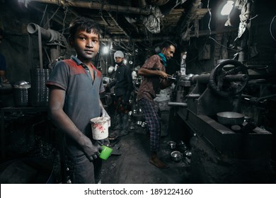 DHAKA, BANGLADESH - JANUARY 10, 2021: A local dark factory or sweatshop in Bangladesh where underaged young kids are doing child labour under dangerous and risky circumstances without compliance