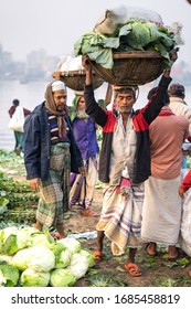 Dhaka / Bangladesh - January 20, 2019: Environmental Portrait Of A Bengali Man Carrying Vegetables In A Basket On His Head, In Sadarghat Market