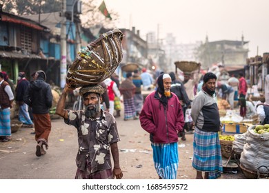 Dhaka / Bangladesh - January 20, 2019: Environmental Portrait Of A Bengali Man Carrying Vegetables In A Basket On His Head, In Sadarghat Market