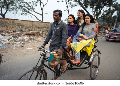 Dhaka / Bangladesh - January 25, 2020: Three Young Women Travel In A Rickshaw Driven By A Man In The Streets Of A Slum In Dhaka