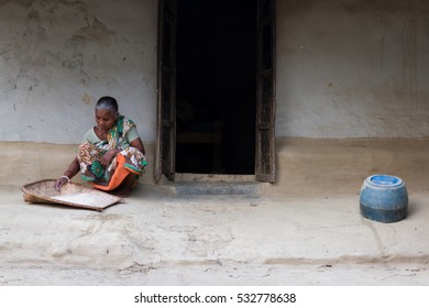 DHAKA, BANGLADESH - MARCH 19, 2016: An Old Female Tea Laborer Was Prep Rice For Her Family For Dinner Sitting Outside Her Home.